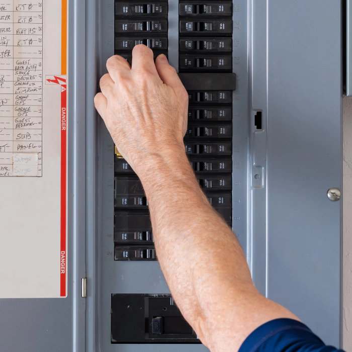 electrician working on circuit breaker box